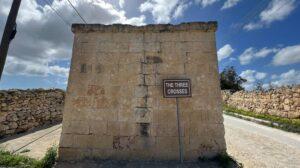 A blank wall with a plaque reading "the Three Crosses"