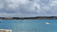 The sea and land seen in the background with clouds in the sky