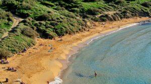 A sandy beach side with greenery on top