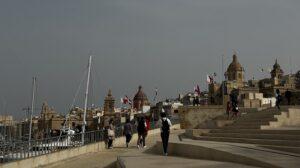 Approaching Birgu on a grey weather day, with flags flying all over the town