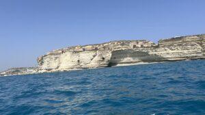 A cliffside at the distance with low fortifications built into the rock