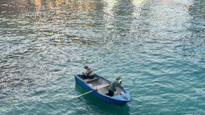 A simple fishing boat in Balluta Bay with two men atop