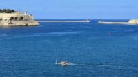 The Grand Harbour entrance with a water taxi crossing it