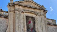 A photo of a church with an image of Jesus Christ sashed in white and red on the exterior